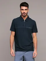 Chomba de manga corta Calvin Klein color azul marino, con cuello polo y cierre frontal parcial con cremallera. Presenta una banda horizontal en el pecho con el logo de la marca bordado.
