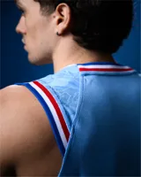 Camiseta de básquet Umbro de edición especial del Club Nacional de Football, color celeste con detalles en azul, blanco y rojo en el cuello y las sisas. Presenta el logo de Umbro y el escudo del club bordados en el pecho.