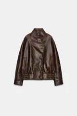 Chaqueta bomber de efecto piel en color marrón oscuro, con cuello subido, cierre frontal cruzado con botones a presión, bolsillos laterales y bajo elástico.