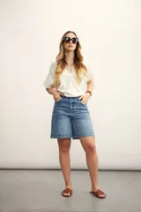 Blusa blanca con diseño cruzado, escote en V y mangas cortas.