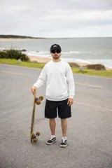 Buzo blanco de punto con cuello redondo y mangas largas. Diseño minimalista y corte clásico.