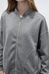 Campera bomber negra de manga larga, con cierre frontal y bolsillos.