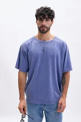 Remera de manga corta con mangas ranglán, color azul con efecto lavado o acid wash. Presenta cuello redondo y corte holgado.