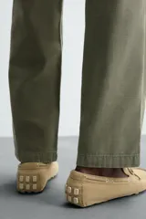 Mocasín casual de cuero color marrón claro con acabado serraje, horma redonda, detalle de lazo en el empeine y suela de goma.