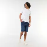 Bermuda vaquera slim fit de corte clásico y color azul, con diseño de cinco bolsillos y cierre frontal con botón y cremallera.