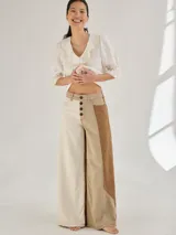 Pantalon ancho de denim en varios tonos de azul con diseño patchwork, de tiro medio y cierre frontal con botones.