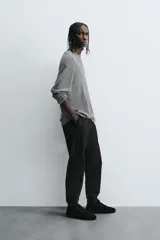 Pantalón tipo jogger de corte slim fit, confeccionado en tejido de algodón con elasticidad. Presenta cintura elástica ajustable con cordón, bolsillos frontales, bolsillos traseros de vivo y bajos con puños elásticos.