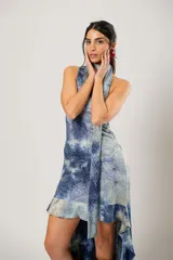 Vestido corto con estampado abstracto en tonos azules y beige. Presenta escote halter con pañuelo al cuello, corte irregular y ruedo con volados.