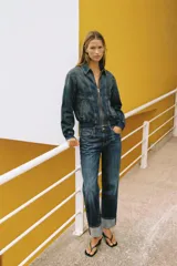 Campera bomber de denim en color gris oscuro con efecto lavado, cuello camisero, cierre frontal de cremallera metálica, bolsillos laterales ribeteados y terminaciones elásticas en puños y cintura.