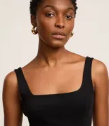 Blusa negra de corte regular, confeccionada en tejido Rib de algodón, con escote cuadrado y breteles anchos.