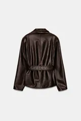 Chaqueta de Zara Woman Collection confeccionada en tejido efecto piel con textura granulada. Presenta cuello solapa, manga larga y cierre frontal con cinturón ajustable mediante lazada. Incluye forro interior.