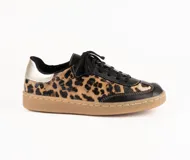 Zapatilla de estilo retro confeccionada en cuero vacuno, con diseño combinado en cuero negro y estampado animal print. Presenta detalles en cuero metalizado dorado en el talón, cordones negros y suela de goma color caramelo con costura reforzada.