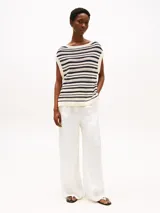 Sweater sin mangas de punto calado a rayas horizontales color crema y azul marino, con cuello barco y logo metálico de Tommy Hilfiger en el bajo.