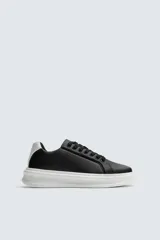 Zapatillas deportivas blancas de caña baja, con detalle de color negro en el talón y suela con volumen.