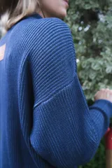 Campera tejida de punto con textura de rayas verticales, cierre frontal completo y cuello alto. Diseño de manga larga con hombros caídos.