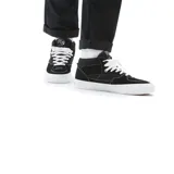 Championes Vans modelo Skate Half Cab, de corte medio, color negro con costuras blancas en contraste. Presenta el parche lateral característico de la línea Half Cab, cordones blancos y suela de goma vulcanizada blanca.