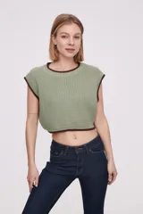 Chaleco corto de punto color marrón con ribete amarillo en cuello, sisas y bajo.