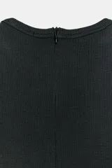 Mono largo negro con cuerpo de tejido ajustado sin mangas y cuello redondo, combinado con pantalón ancho de tejido fluido y satinado con diseño abullonado y bajo asimétrico. Cierre trasero con cremallera oculta.