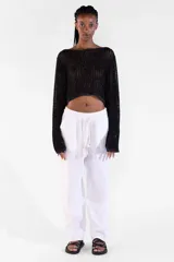Sweater crop de manga larga tejido con hilos de distintos tonos y lurex que aporta brillo sutil, con escote amplio y detalle de moneda metálica Polonio en color rose gold.