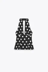 Top negro con estampado de lunares blancos, cuello halter, escote en pico y lazo en la espalda.