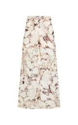 Pantalón de tul Le Lis Blanc modelo Marfim, de pierna ancha y corte fluido, con estampado abstracto en tonos beige y marrón. Cuenta con cinturilla drapeada en la parte delantera y forro interior corto.