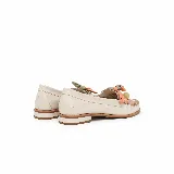 Mocasín de cuero color off-white vainilla, con taco bajo, punta redondeada y detalles artesanales de tiras entrelazadas en tonos pastel y aplique colgante con cuenta translúcida en el empeine.