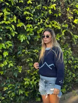 Sweater tejido a mano en lana merino 100% natural teñida artesanalmente, de color azul con detalle de colina en tono celeste.