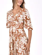 Vestido largo marrón con estampado floral blanco, escote en V cruzado y mangas cortas amplias.