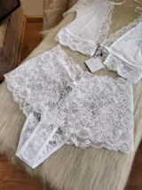 Conjunto de lencería compuesto por un top de encaje con mangas cortas y escote profundo, y una bombacha tipo hipster de encaje completo.