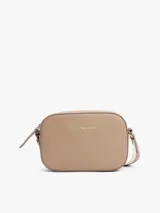 Cartera tipo camera bag de Tommy Hilfiger en color beige, con acabado granulado y logo de la marca en letras doradas en el frente. Cuenta con cierre de cremallera superior, compartimento principal, bolsillo interior abierto y bolsillo interior con cremallera. Incluye una correa ajustable de tejido textil con detalles distintivos de la marca.