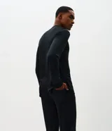 Conjunto de pijama masculino compuesto por una remera de manga larga con cuello redondo y un pantalón largo a juego. Ambas piezas presentan un diseño liso y minimalista, confeccionadas en tejido de modal suave y transpirable.