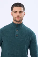 Buzo tejido texturado color verde oscuro, con cuello alto y cierre parcial de tres botones. Tiene mangas largas y un pequeño detalle de etiqueta marrón en el dobladillo inferior.