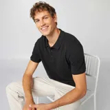 Remera polo negra de piqué de algodón, con cuello clásico y tapeta de dos botones.