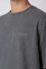 Remera de algodón gris con efecto acid wash, corte regular, mangas cortas y cuello redondo. Cuenta con un pequeño bordado tono sobre tono en el pecho y una etiqueta lateral distintiva de la marca en el ruedo.