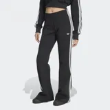 Pantalón acampanado Adidas de la colección Adicolor, color negro con las icónicas tres tiras blancas a los lados y el logo del trifolio bordado.