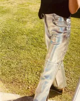 Pantalón slouchy de cuero ovino color plateado, corte mom fit con tiro semi alto y tajos inferiores.