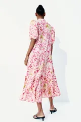 Vestido largo de algodón color rosa con estampado floral, cuello mao, mangas globo cortas, cinturón fino extraíble y falda acampanada con fruncido escalonado.