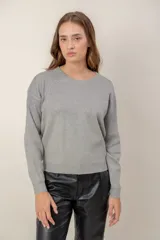 Sweater de punto con cuello redondo y mangas largas, presenta un diseño con efecto degradado metalizado en la parte superior y hombros.