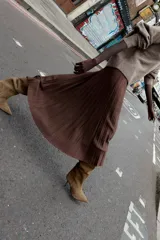 Bota de caña alta confeccionada en serraje color marrón, con diseño de punta fina y tacón alto tipo aguja. Presenta una estructura de calce fácil tipo pull-on.