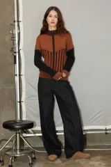 Campera de punto con cierre frontal, diseño bicolor en tonos bordó y rojo, con mangas largas y textura combinada de tejido liso y acanalado.