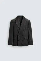 Blazer de corte regular confeccionada en pana de algodón, con diseño de botonadura cruzada. Presenta cuello con solapas de pico, manga larga con puños abotonados, bolsillos con solapa en la cadera y abertura central en la espalda.