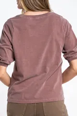 Remera de algodón color blanco roto, con escote redondo y mangas globo de tres cuartos con elástico en el puño.