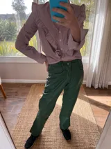 Pantalón slouchy de cuero ovino color verde inglés, corte mom fit con tiro semi alto y tajos inferiores.