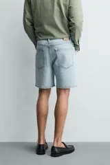 Bermuda de jean con corte regular fit, confeccionada en denim de algodón con elasticidad. Presenta diseño de cinco bolsillos, efecto lavado y cierre frontal con cremallera y botón.