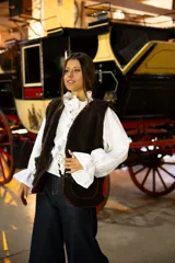 Chaleco de corderito color chocolate, con diseño sin mangas, corte recto y cierre frontal con botones.