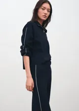 Pantalón de punto azul marino de corte recto y tiro alto, con ribete blanco en los laterales.