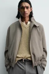 Cazadora de corte relajado confeccionada en tejido con lana, con diseño de pata de gallo en tonos marrones. Presenta cuello subido con cierre de botones, bolsillos laterales de vivo y acabados elásticos en puños y bajo.