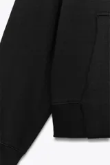 Sudadera de manga larga con capucha ajustable mediante cordones, bolsillo frontal tipo canguro y puños y ruedo en tejido rib.