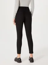 Pantalón de jean negro de corte skinny y cintura media, con cierre frontal y bolsillos laterales.