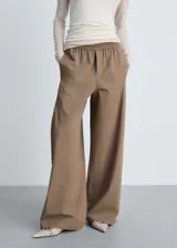 Pantalon wideleg color tostado con cintura elástica, tiro medio y bolsillos laterales. Diseño largo de corte holgado con forro interior.